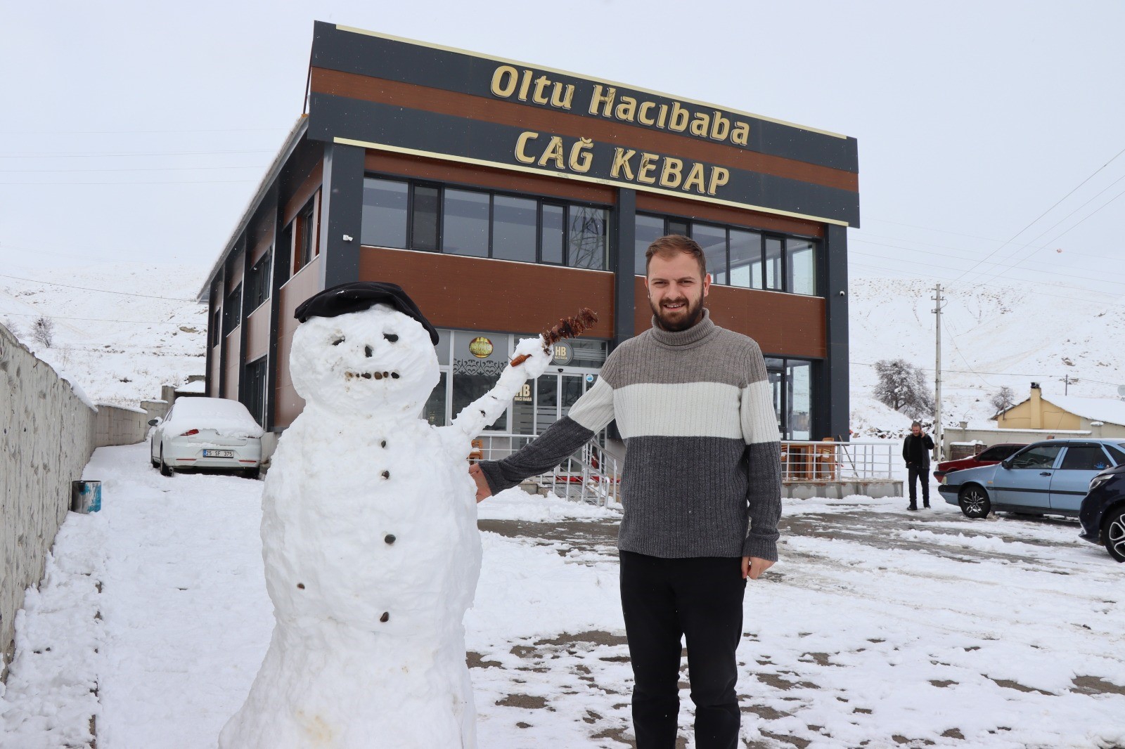 Kardan adam, iş yerine gelenleri cağ kebabı ile karşılıyor